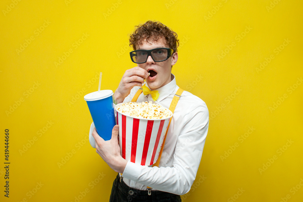 guy in festive outfit in 3d glasses watches movie with popcorn, nerd student in bow tie and suspenders cinema viewer guy in festive outfit in 3d glasses watches movie with popcorn, nerd student in bow tie and suspenders cinema viewer