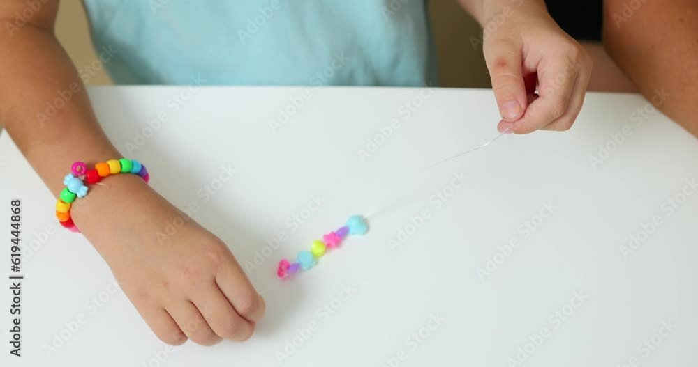 Process of making a bracelet from a thread and colored beads Process of making a bracelet from a thread and colored beads