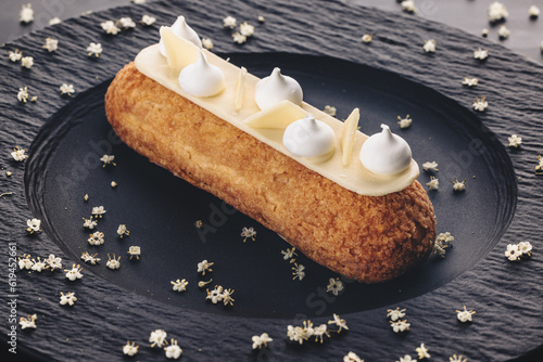 Принти на полотні French eclair grazed with chocolate or sweet Italian profiteroles on a black sto