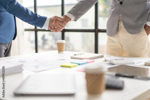 Two business people shake hands after a business deal is reached In the office area