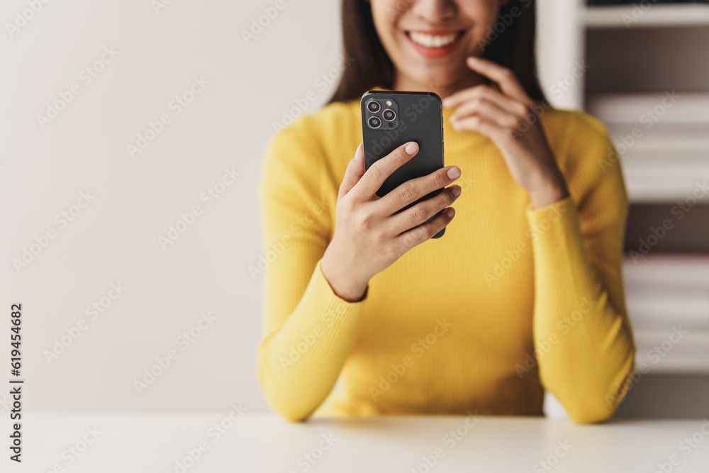 Portrait of a young woman holding a mobile phone to use social media on a smartphone. Communicate via the Internet on a smartphone. concept of using technology in communication Portrait of a young woman holding a mobile phone to use social media on a smartphone. Communicate via the Internet on a smartphone. concept of using technology in communication