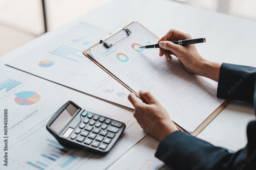 Accountant working on desk using calculator to calculate financial report in office business accounting finance concept Accountant working on desk using calculator to calculate financial report in office business accounting finance concept