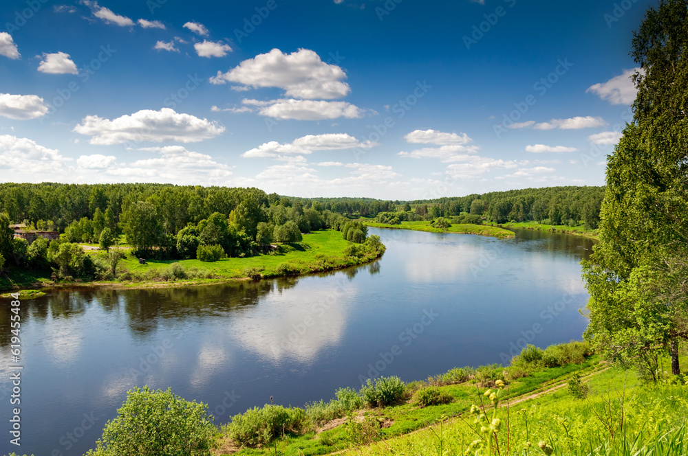 Beautiful summer landscape of meadows near the river and forest. The upper reaches of the Volga River in the Tver region of Russia.