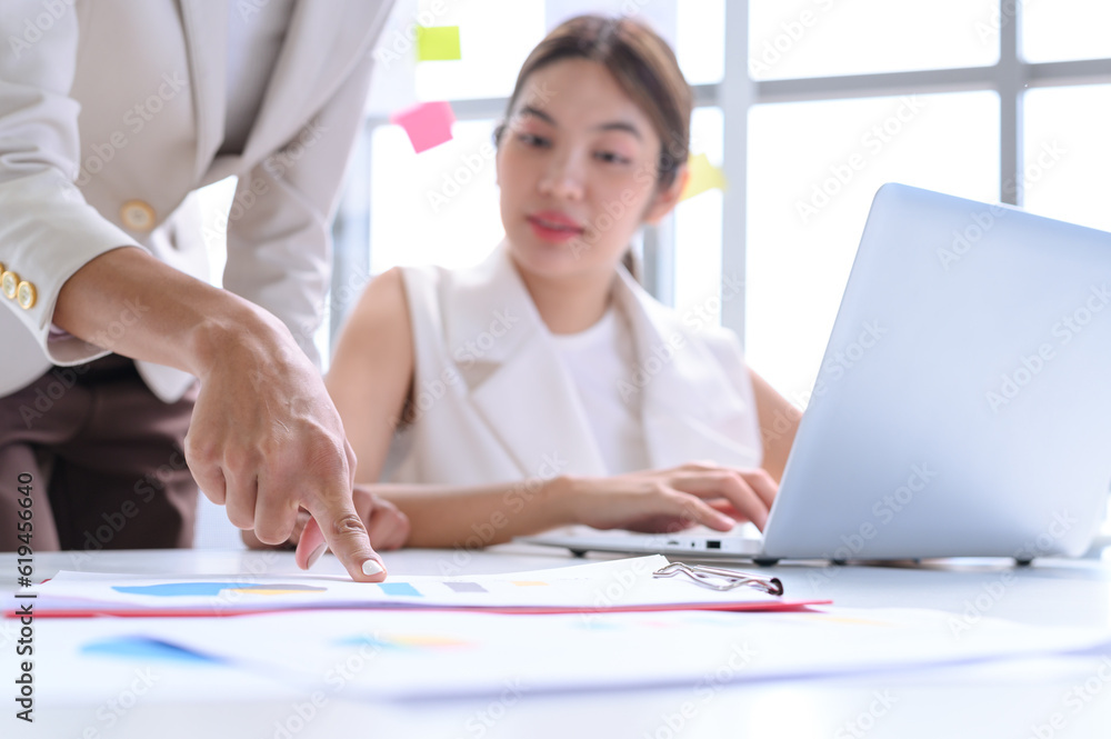 Attractive senior businesswoman train or mentor and coach their colleagues and point finger to document reports. Select focus to finger. Attractive senior businesswoman train or mentor and coach their colleagues and point finger to document reports. Select focus to finger.
