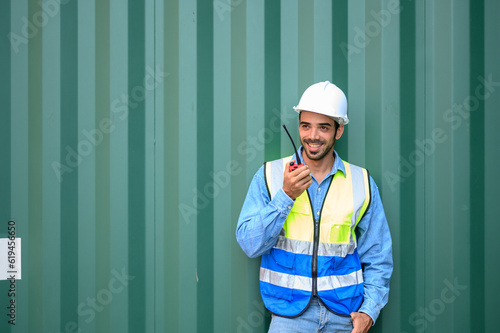 container operators wearing helmets and safety  vests control via walkie-talkie workers in container yards. Cargo Ship Import Export Factory Logistic.