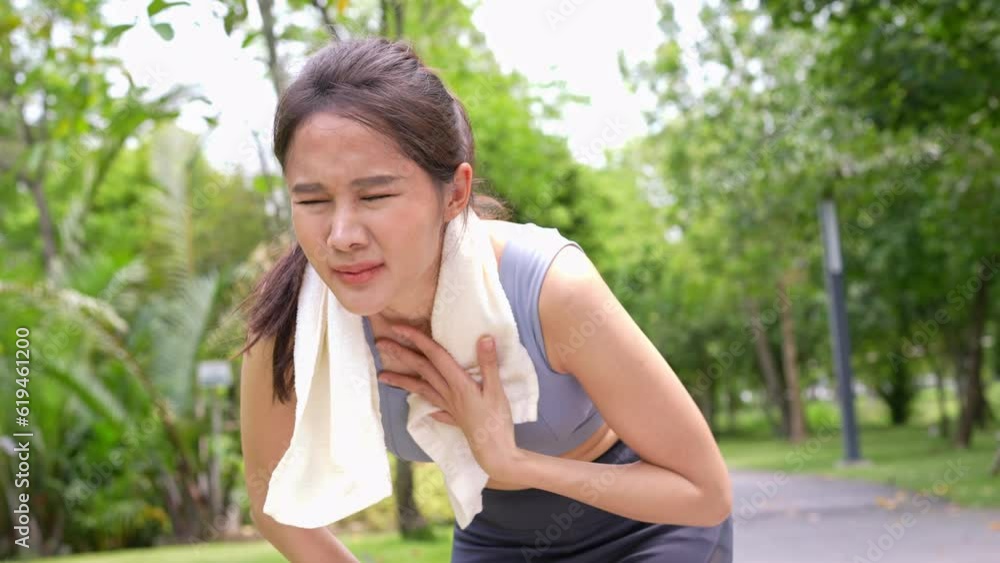 Sport asian woman gets tired and get dizzy, feel bad pain and suffer from heat stroke outdoors when jogging or exercise outdoor with strong sunlight in summer season. Heatstroke and heat wave concept. Sport asian woman gets tired and get dizzy, feel bad pain and suffer from heat stroke outdoors when jogging or exercise outdoor with strong sunlight in summer season. Heatstroke and heat wave concept.