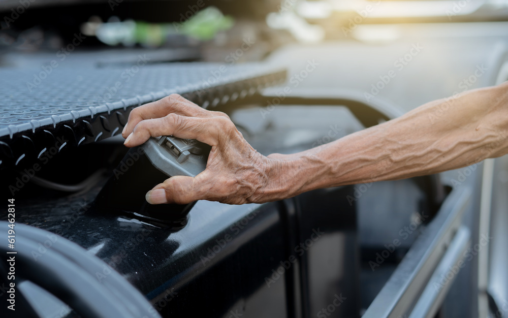 Obraz premium Close up elderly man hand open the cap of fuel tank of a truck .