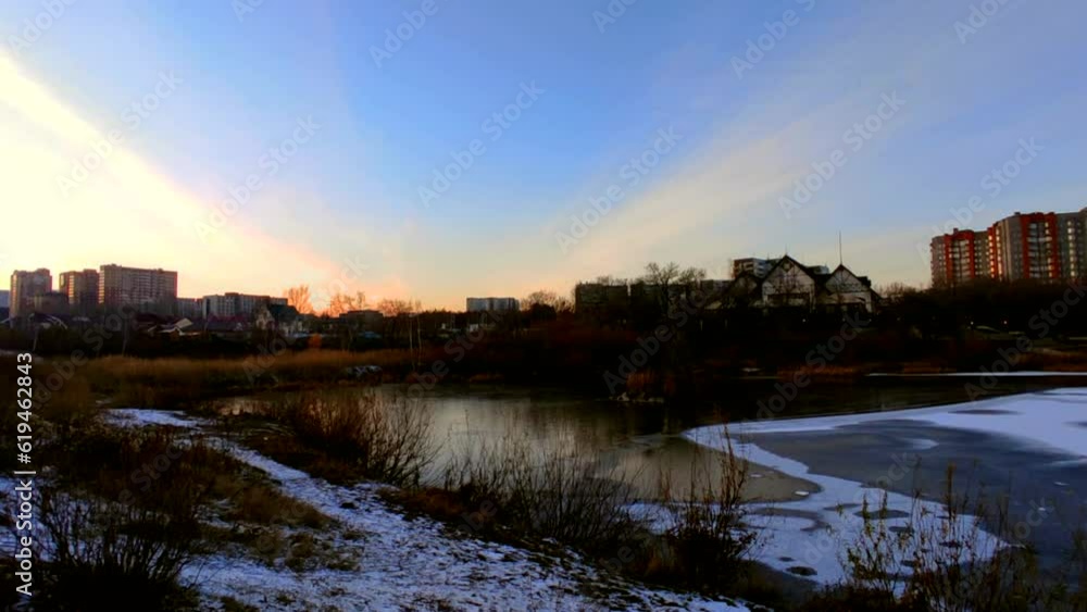 Lake half covered in ice with ducks