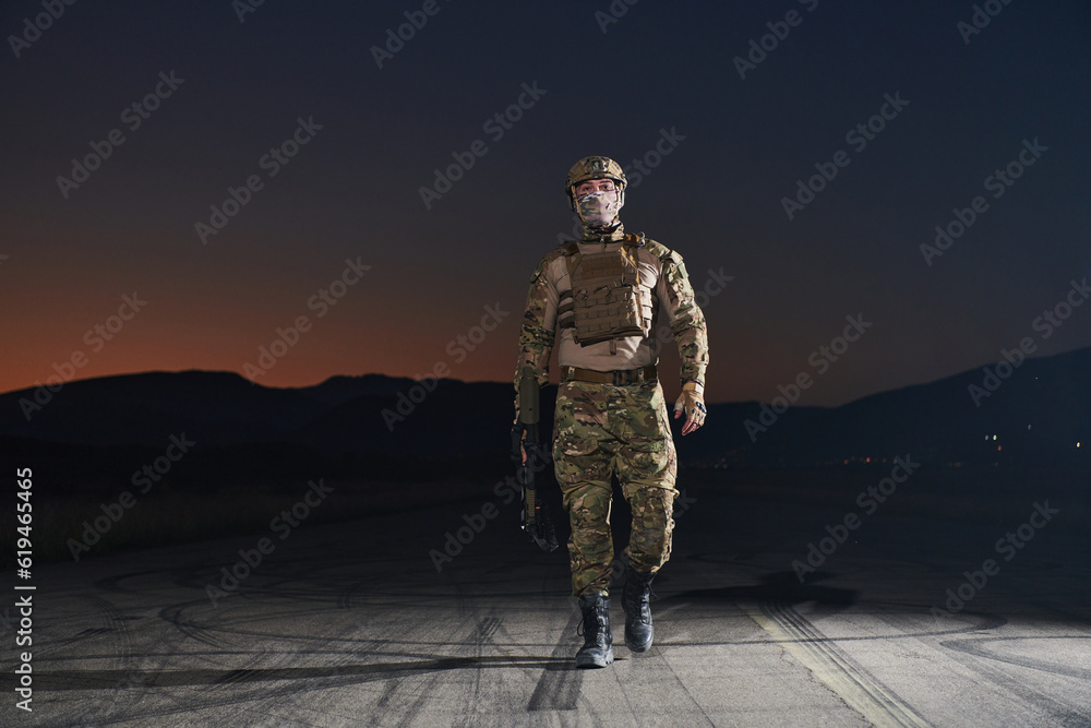 A professional soldier in full military gear striding through the dark night as he embarks on a perilous military mission A professional soldier in full military gear striding through the dark night as he embarks on a perilous military mission