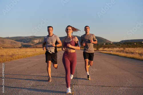A group of young athletes running together in the early morning light of the sunrise, showcasing their collective energy, determination, and unity 