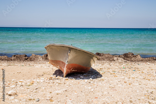 A wooden boat on the quiet beach with no one, by the sea