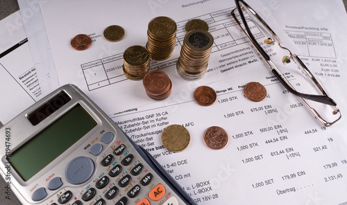 The currency of the European Union with a calculator, glasses, bills on the table.