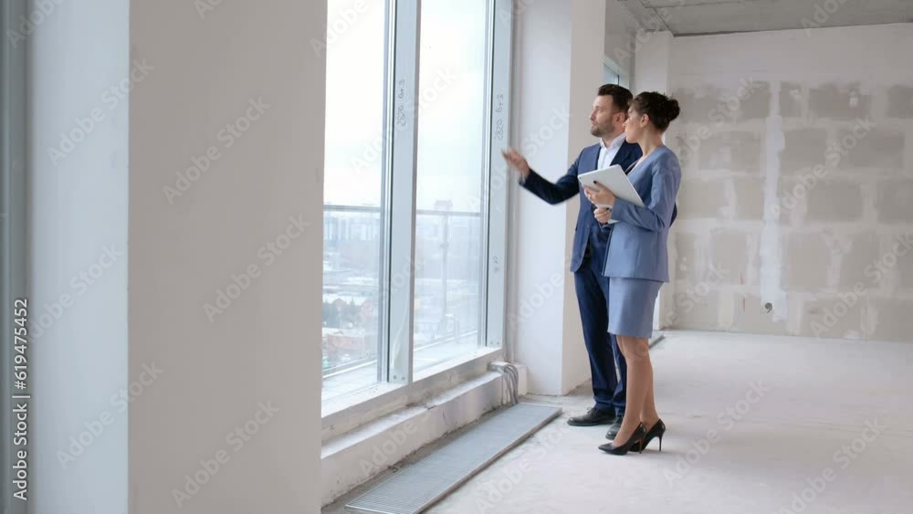 Two business persons talking about investment in real estate indoors. Construction concept: female agent speak with consultant Two business persons talking about investment in real estate indoors. Construction concept: female agent speak with consultant