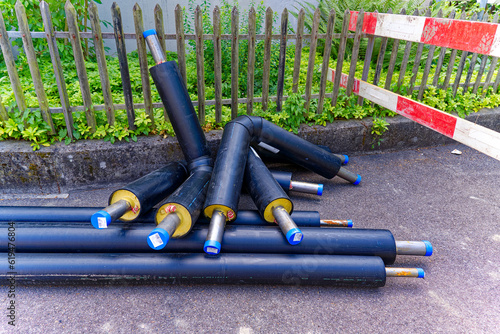 Construction site of apartment building with heap of black piepes of district heating at City of Zürich district Schwamendingen on a sunny summer day. Photo taken July 3rd, 2023, Zurich, Switzerland. photo