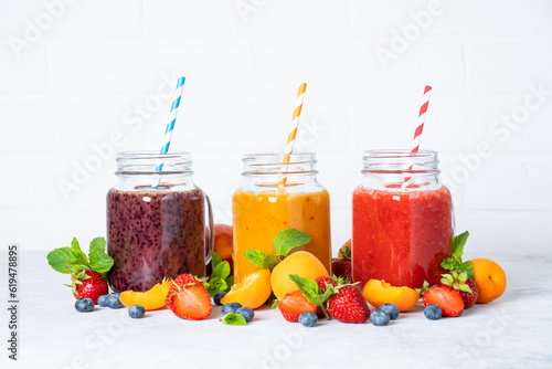 Smoothie with fresh fruits and berries at white background.