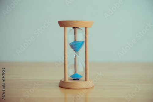 Hourglass vintage style on wooden table wall background. Abstract time management in business, job, career concept.