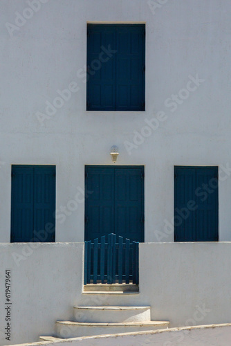 Old traditional style white house with blue wooden door and windows in Mykonos  Cyclades  Greece.