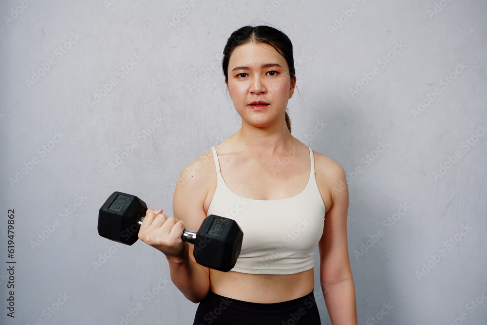 young woman lifting dumbbells exercising in the gym fitness concept. young woman lifting dumbbells exercising in the gym fitness concept.
