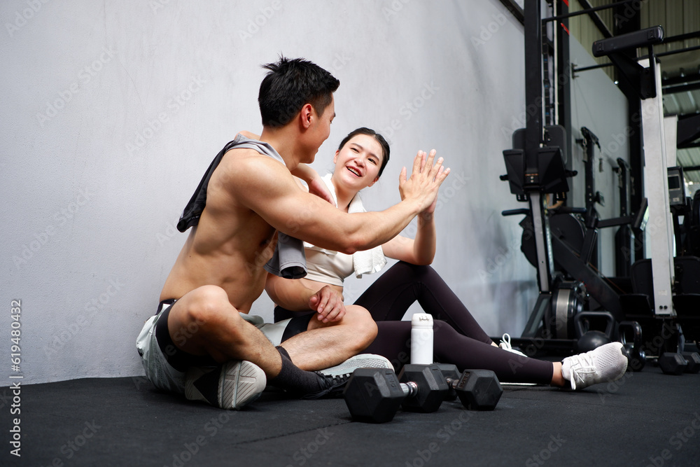 Obraz premium Young woman and young man exercising in the gym fitness concept.