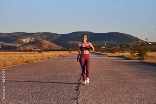Healthy young couple jogging in the city streets in the early morning with a beautiful sunrise in the background