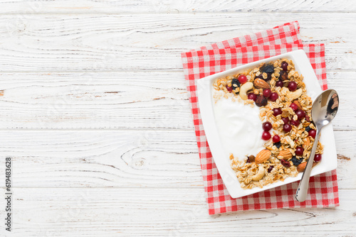 Healthy breakfast food with granola, yogurt, fruits and nuts. Dessert parfait with dried fruits for breakfast