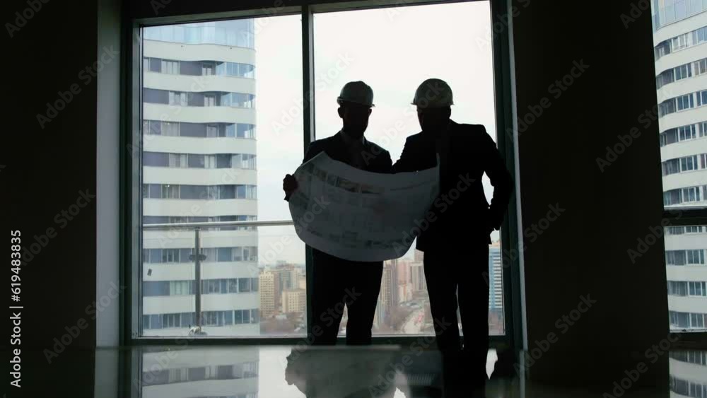 Construction concept: two colleagues man engineer and consultant in helmet discussion about project and checking plan closeup Construction concept: two colleagues man engineer and consultant in helmet discussion about project and checking plan closeup