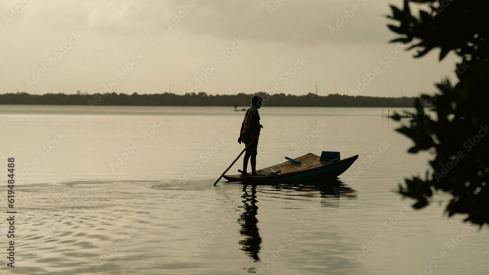 man fishing a middle of river 