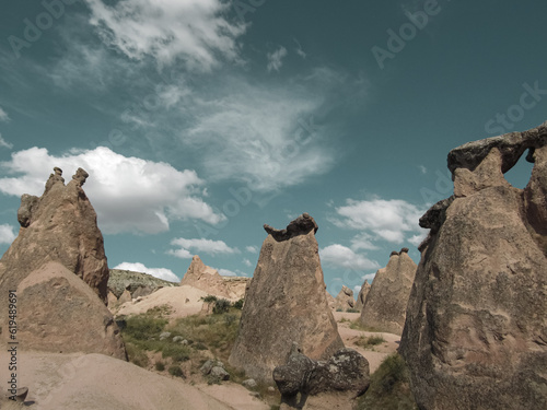 The shot of fairy chimneys, distinctive geological formations, captured against the backdrop of a blue sky adorned with cirrus and cumulus clouds. Landscape photograph. © Zeynep