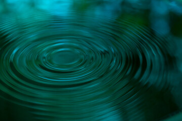 Ripple of water or water drop splash on green nature background. Abstract shape out of the water