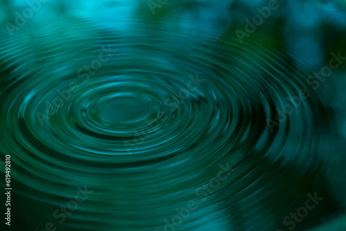 Ripple of water or water drop splash on green nature background. Abstract shape out of the water