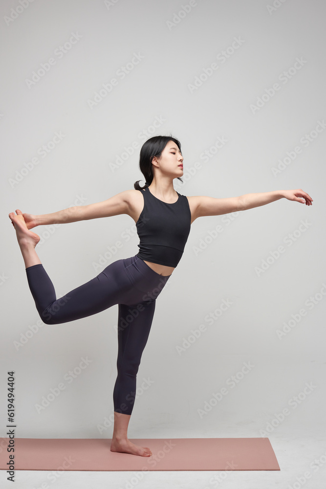 beautiful Asian woman practicing yoga indoors 
