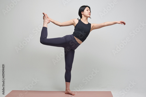 beautiful Asian woman practicing yoga indoors 
