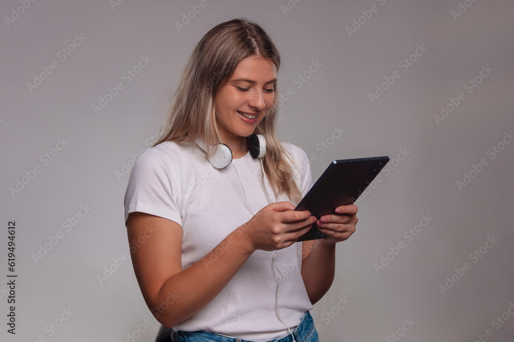Portrait of young woman using tablet, isolated on gray background Portrait of young woman using tablet, isolated on gray background