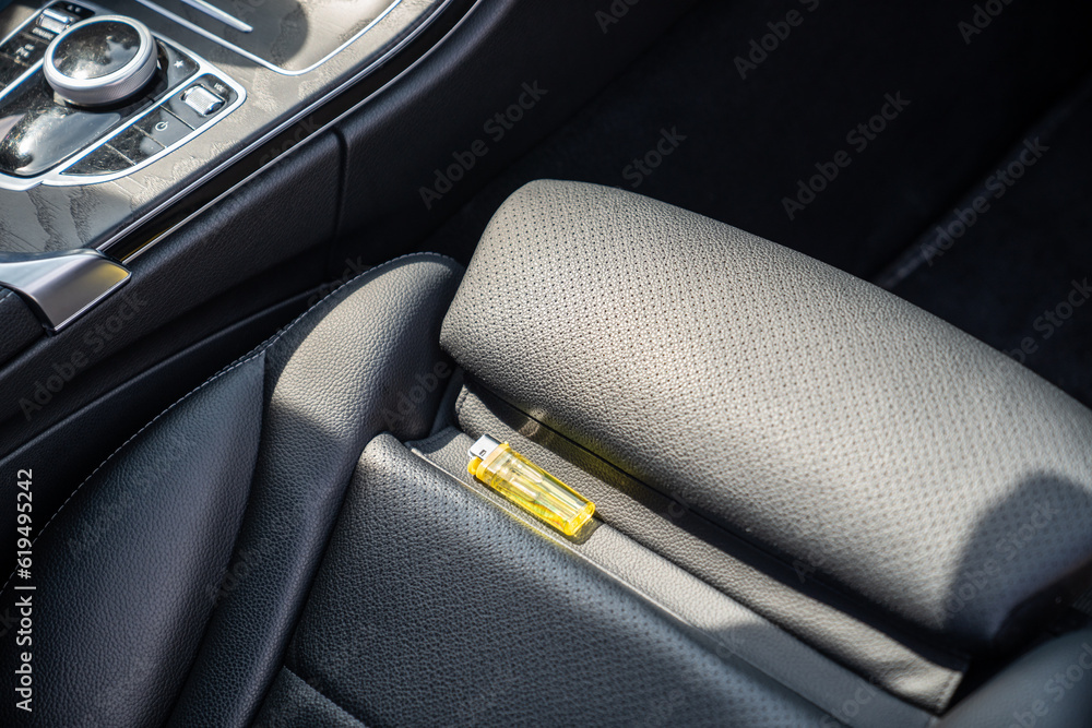 Lighter in car on hot sunny day. High temperatures in summer can cause explosions and fires. Things that should not be forgotten and left unattended. Explosive objects concept. Lighter in car on hot sunny day. High temperatures in summer can cause explosions and fires. Things that should not be forgotten and left unattended. Explosive objects concept.