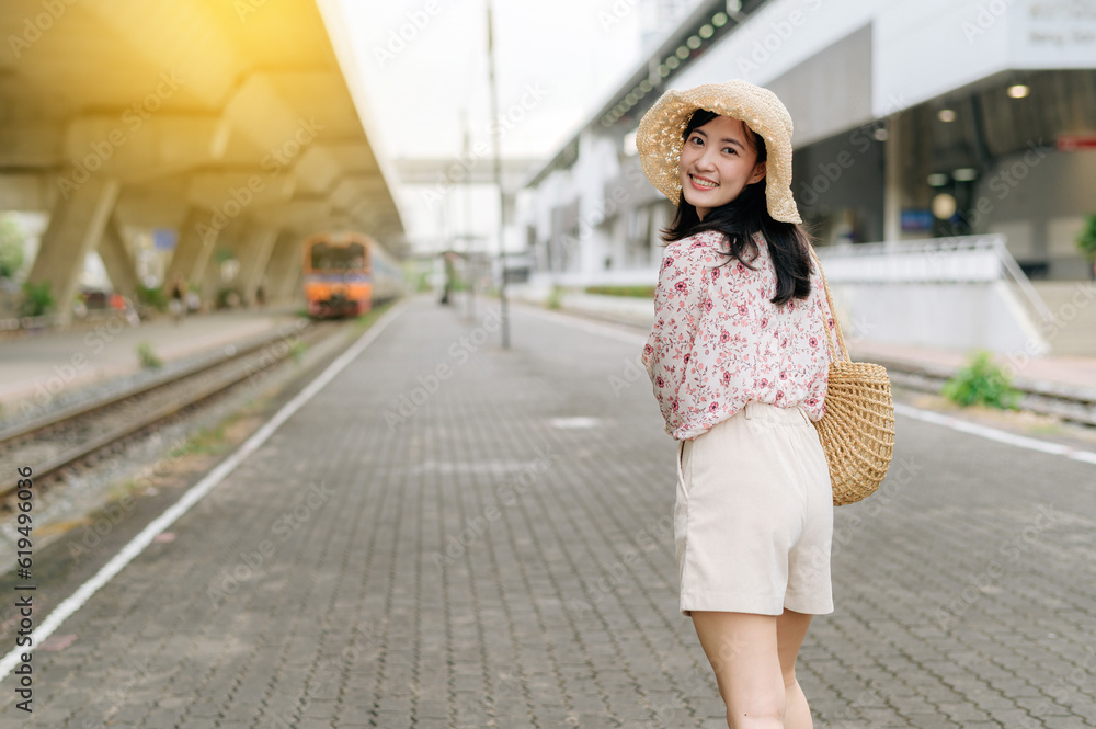 young asian woman traveler with weaving basket looking back happy smiling to a camera beside train coming background. Journey trip lifestyle, world travel explorer or Asia summer tourism concept. young asian woman traveler with weaving basket looking back happy smiling to a camera beside train coming background. Journey trip lifestyle, world travel explorer or Asia summer tourism concept.