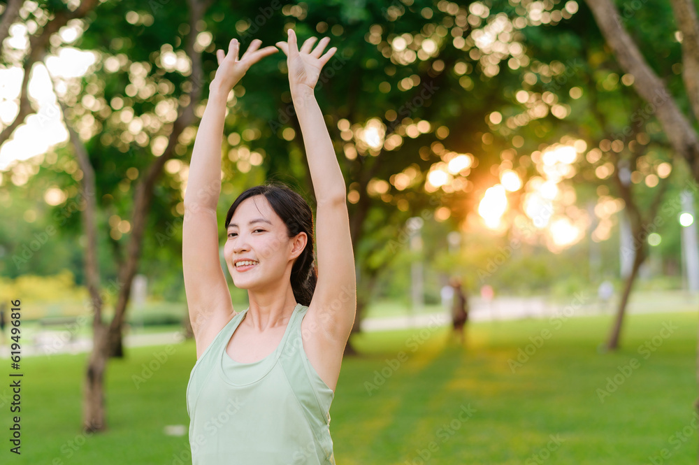 Female jogger. Fit young Asian woman with green sportswear stretching muscle in park before running and enjoying a healthy outdoor. Fitness runner girl in public park. Wellness being concept Female jogger. Fit young Asian woman with green sportswear stretching muscle in park before running and enjoying a healthy outdoor. Fitness runner girl in public park. Wellness being concept