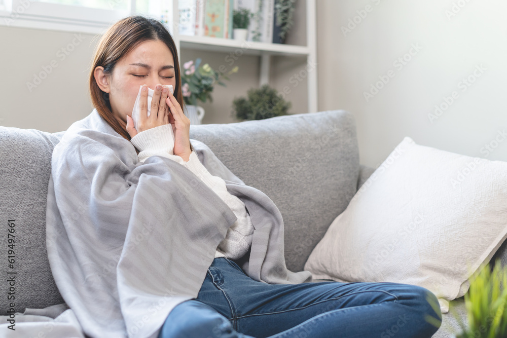 Seasonal sick concept. the young woman has a common cold and sneezing on the sofa. Seasonal sick concept. the young woman has a common cold and sneezing on the sofa.