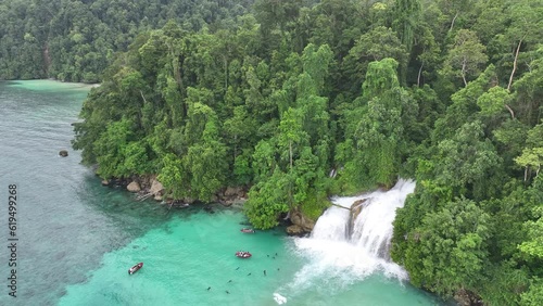 The scenic Momon waterfall tumbles from the primordial rainforest of West Papua into the shallow sea. This spectacular waterfall is found about a day's sail north of Kaimana.   photo