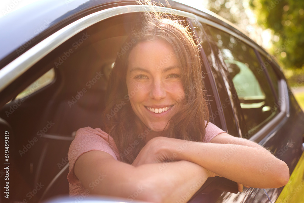 Portrait Of Woman Looking Out Of Passenger Car Window On Road Trip Vacation