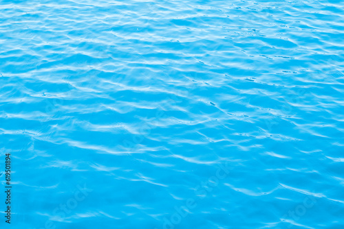 The blue surface of the pool water glistens in the sun