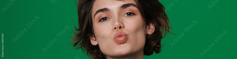 Obraz premium Young woman making kiss lips while holding copyspace
