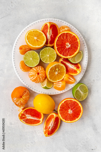 White plate full of fresh citrus fruits  top view