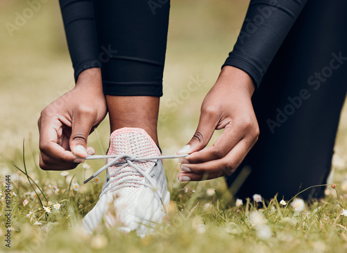 Lace sneakers  person and hands outdoor on grass for running  workout and performance. Closeup of athlete  runner and tie shoes on feet  footwear and exercise at park for sports  fitness and marathon