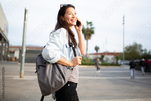 Beautiful young asian woman talking on cell phone outside in city © mimagephotos