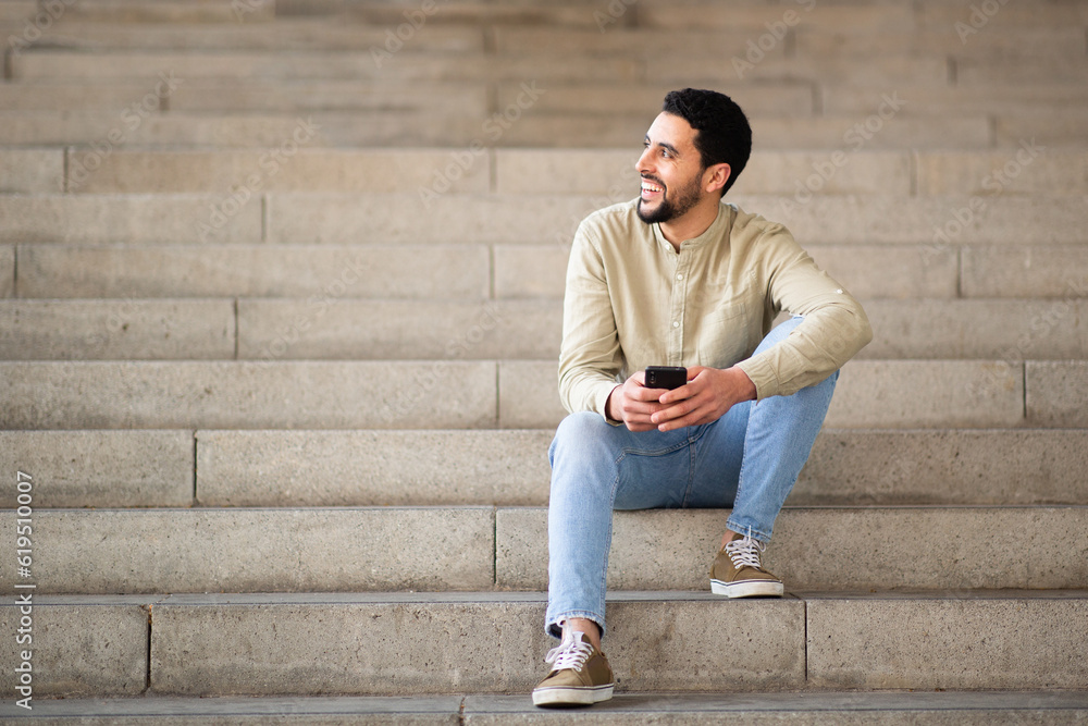 Young arab man sitting on steps with mobile phone Young arab man sitting on steps with mobile phone