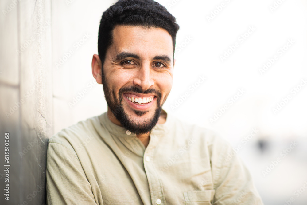 Fototapeta premium Happy handsome arab man leaning to a wall