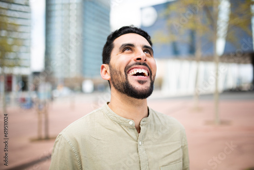 Carefree young arabic man laughing outside