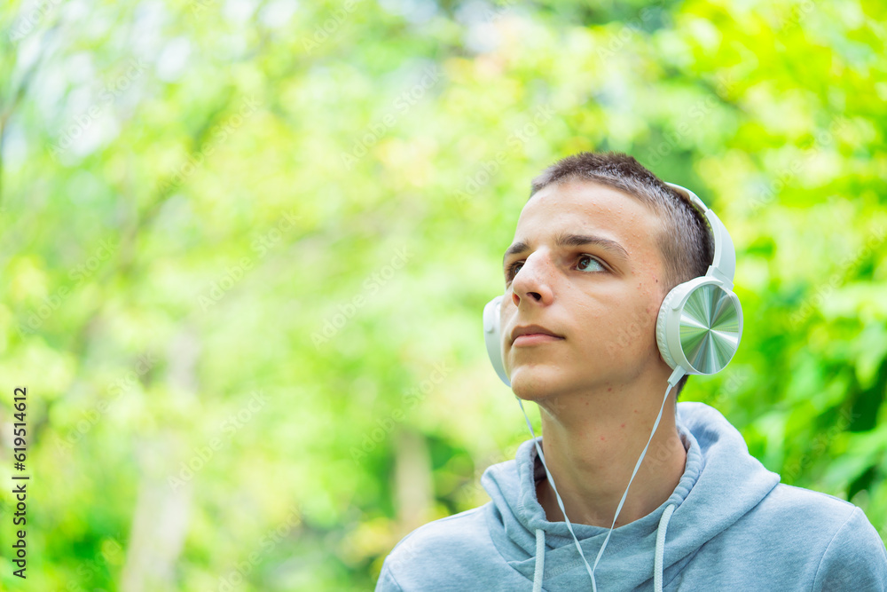 Portrait of a teenager with headphones outdoors,teenager listens to music Portrait of a teenager with headphones outdoors,teenager listens to music