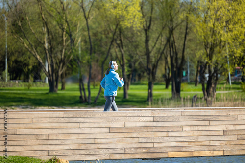 Woman in blue blazer running in the park in the morning