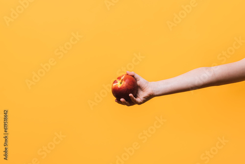 Crop kid with apple over yellow background photo